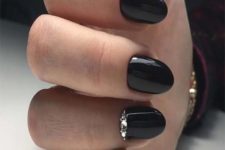 a shiny black manicure accented with rhinstones is a chic and bright idea for winter holiday parties