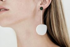 a statement minimalist earring of a black bead and an asymmetrical white stone