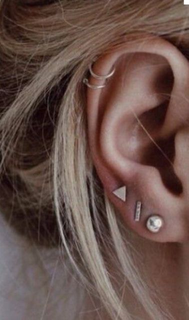 cool multiple piercing styling with metal studs and hoops in the conch is a stylish minimalist idea