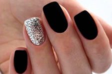 matte black nails paired with a single silver glitter accent nail for a chic and sparkly winter look