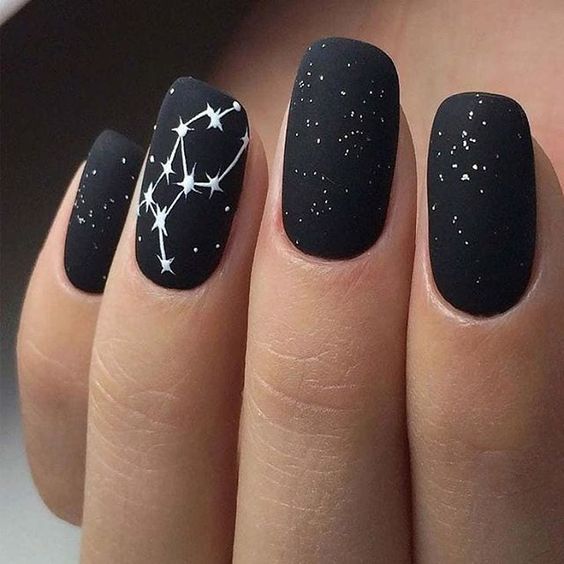 matte black nails wtih white and glitter celestial detailing look super edgy and very chic