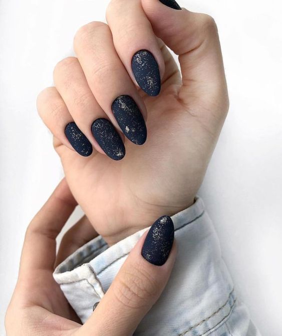 matte nails with gold glitter chaotically placed on them for a more eye-catchy and natural look