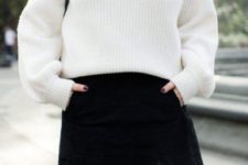 monochromatic look with a white sweater and a black denim mini with porckets plus a black bag