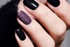 shiny black nails paired with a single mauve glitter accent one for a bolder and moodier look