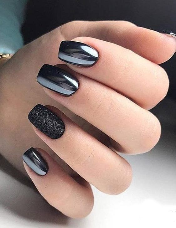 shiny black nails with a single black glitter one for a chic and refined accent