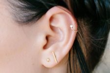 two gold studs paired with a single gold hoop with diamonds for a chic look