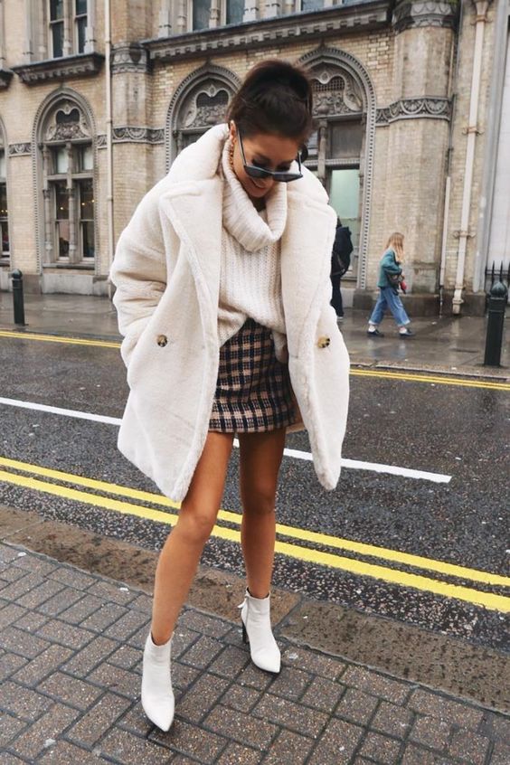 an oversized white chunky knit sweater, a tweed mini skirt, a white faux fur coat and white booties