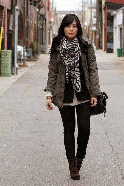 With black pants, brown lace up boots, parka coat and bag