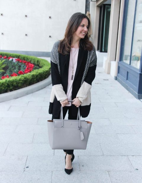 With loose shirt, black pants, gray leather tote bag and black shoes