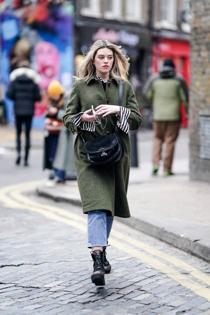 With olive green coat, cropped jeans, striped shirt and black crossbody bag