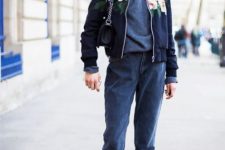 With turtleneck sweater, cuffed jeans, mini bag and floral bomber jacket