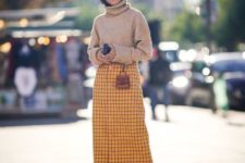 With yellow and black checked midi skirt, checked high boots and mini bag