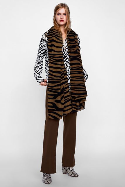 With zebra printed shirt, brown pants and printed leather boots