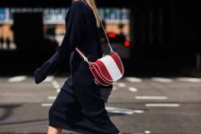a black midi sweater dress, white heeled booties and a red and white striped saddle bag