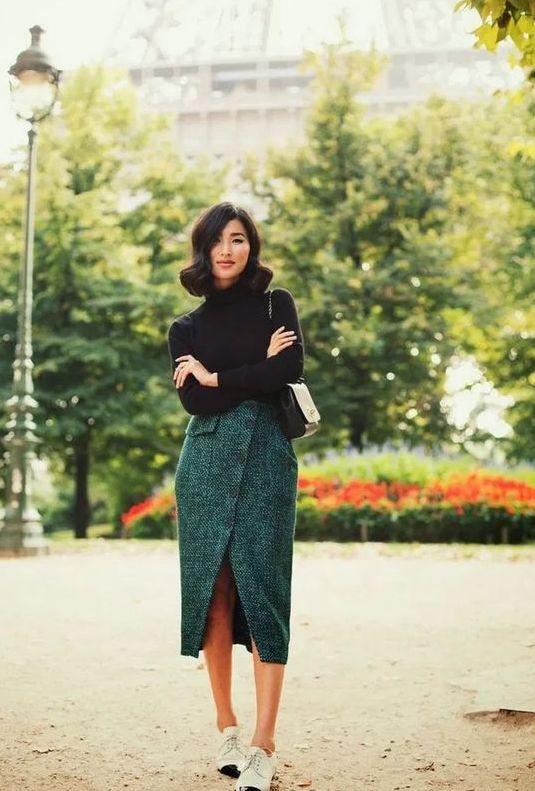 a black turtleneck, a forest green wrap midi skirt on buttons, vintage-inspired two tone shoes and a bag
