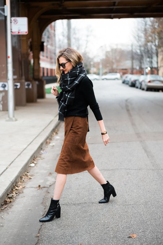 a casual outfit with a black top, a brown suede wrap skirt, black booties and a printed scarf
