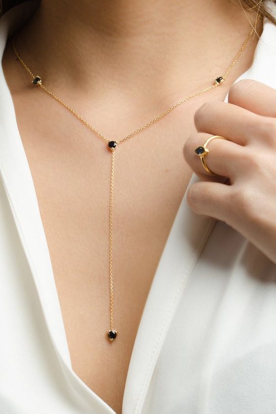 a catchy gold lariat necklace with black rhinetones plus a matching ring for a boho chic look