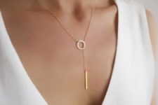 a minimalist gold lariat necklace with a circle and a vertical bar is a chic and bold idea to rock
