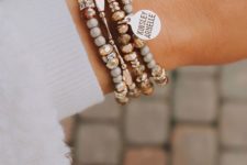 a stack of chic and elegant bracelets with gold and stone beads plus a personalized metal tag for an ultimate look
