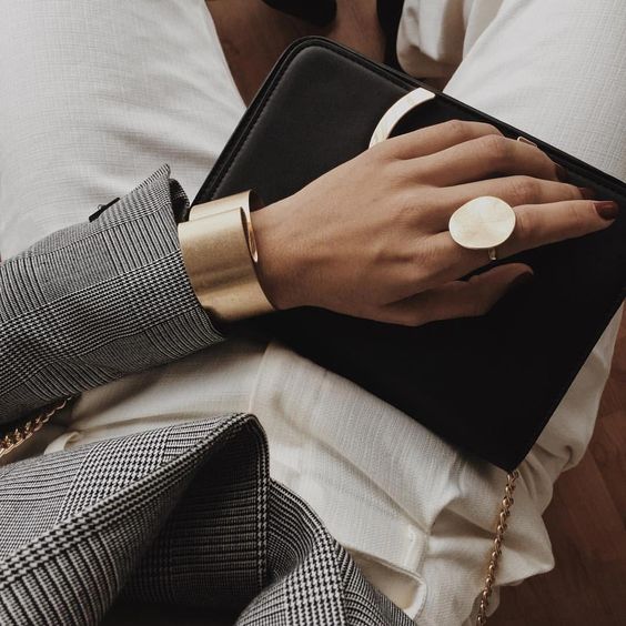 a statement matte gold ring of an irregular shape and a matching bracelet that is also a statement