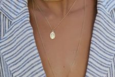 a trio of delicate gold necklaces including a choker, a plunging one with a cross and a little icon
