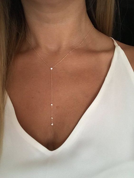 a very delicate rose gold chain lariat necklace with several diamonds is a chic and refined accent in your look