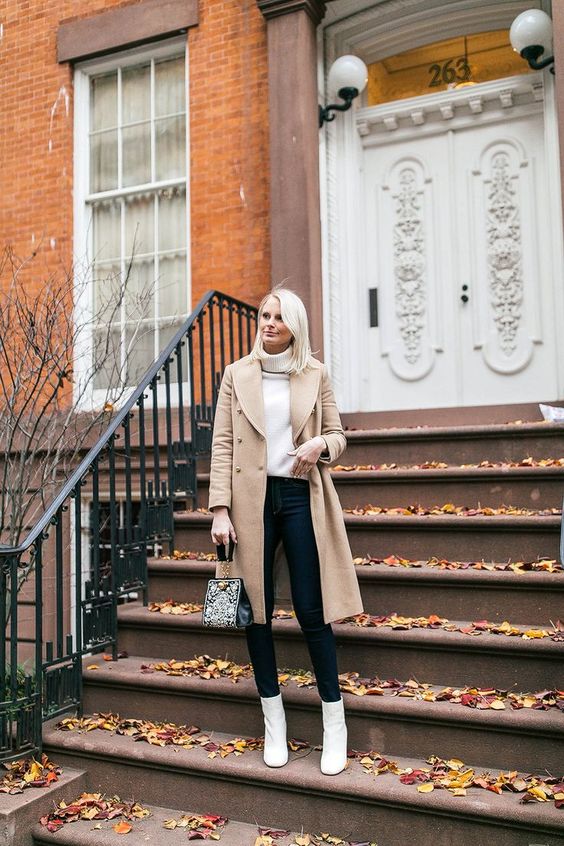 a white turtleneck sweater, black skinnies, white heeled booties, a tan coat and a printed bag