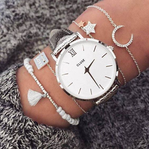 dainty chain bracelets with beads and charms plus a statement watch with a silver strap