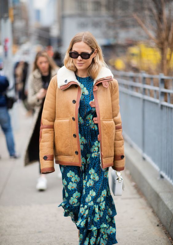 a bright floral print maxi dress with ruffles, a white bag and a shearling coat for a trendy winter look