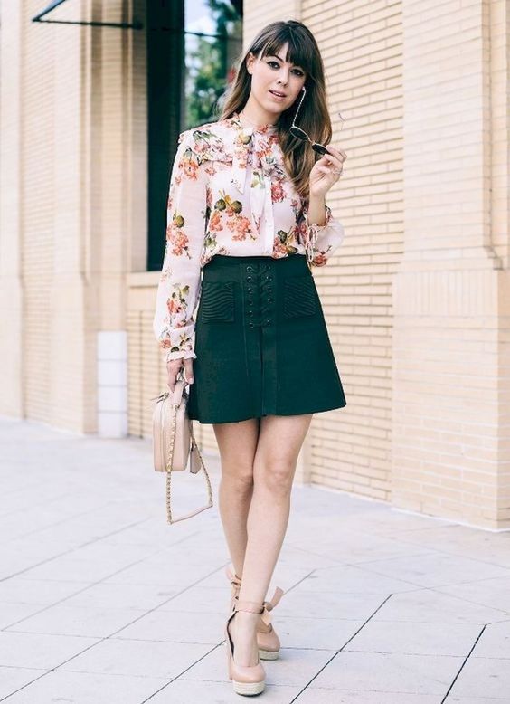a floral blouse with a bow, a dark green lace up skirt, a neutral bag and espadrillas