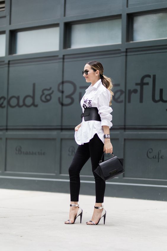 a white oversized shirt, black skinnies, a black leather corset belt, a black bag and two tone shoes