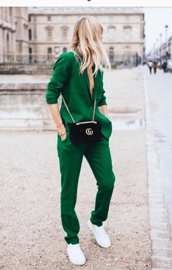 a bright green pantsuit, white sneakers and a black crossbody for a bold look at work