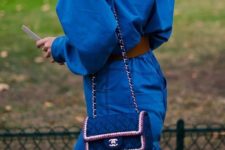 08 a classic blue jumpsuit paired wiht a tiny matching bag with embellishments and embroidery by Chanel