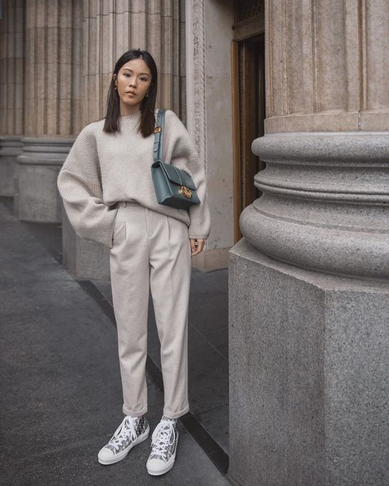 a neutral casual look with an oversized sweater, neutral pants, grey sneakers, a blue bag for winter