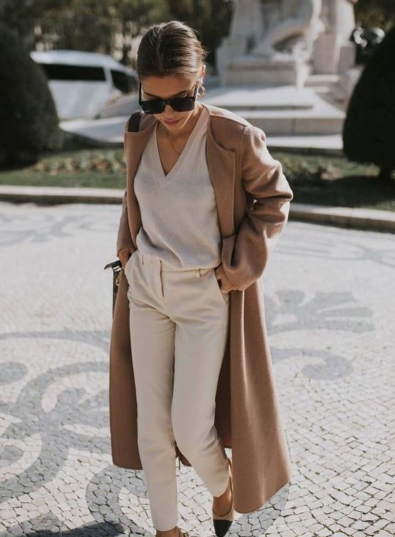 a neutral look with a V-cut sweater, creamy pants, two-tone shoes and a classic camel coat