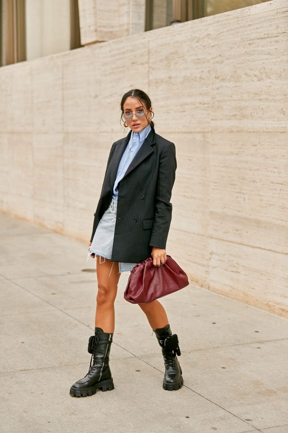 an edgy look with trendy boots and an oversized blazer is crowned with a burgundy soft clutch