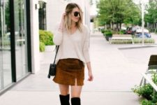 With beige loose shirt, black over the knee boots and black mini bag
