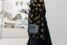With black pleated midi skirt, hat, black bag and black and gray sneakers