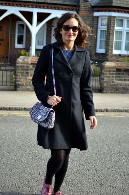 With printed dress, black coat and purple shoes