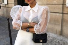 a chic white polak dot blouse with sheer puffy sleeves and a white lace mini skirt with fringe plus a black bag