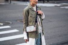 a crochet top, large pearl jeans, white sneakers, an olive green jacket and a neutral bag
