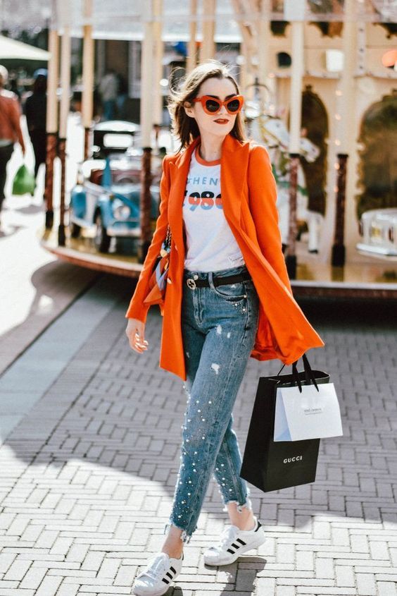 a printed tee, a red blazer, pearled jeans, white sneakers and a black bag for every day