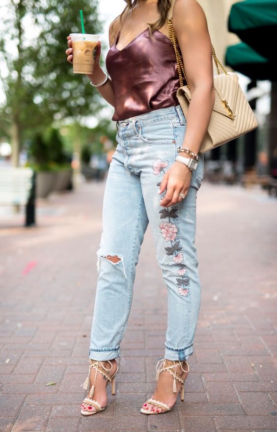 a silk purple top, whitewashed embroidered ripped jeans, lace up shoes and a comfy bag