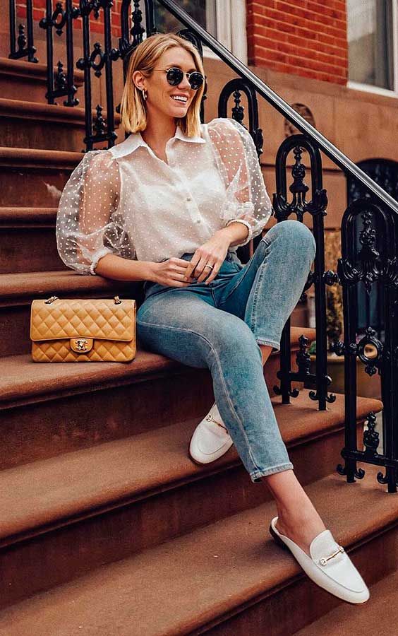 a trendy look with blue skinnies, white moccasins, a white polka dot blouse with puffy sleeves and a buttercup bag
