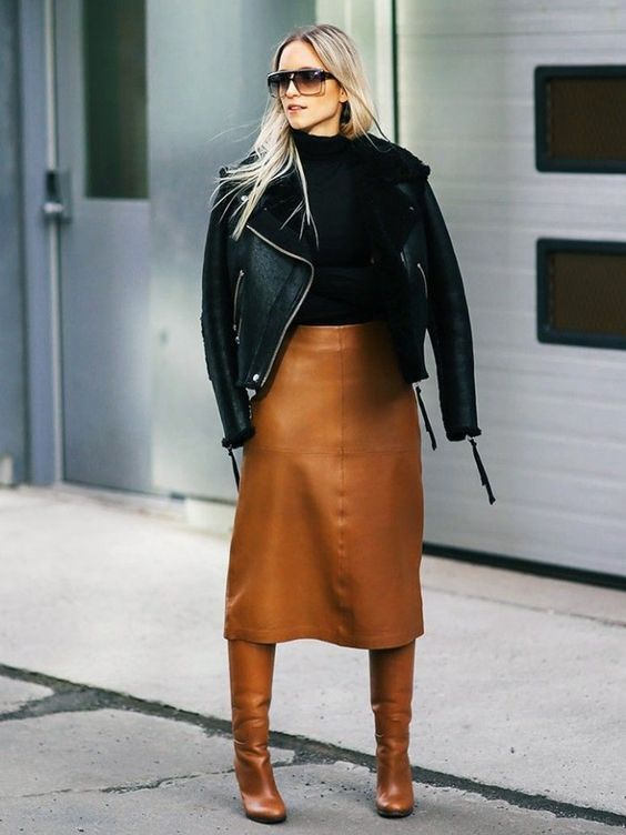 a trendy winter look with a black turtleneck, an amber midi skirt, matching boots and a black shearling coat