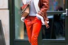 orange leather pants, white booties, a grey sweater, a brown shearling coat and brown bag