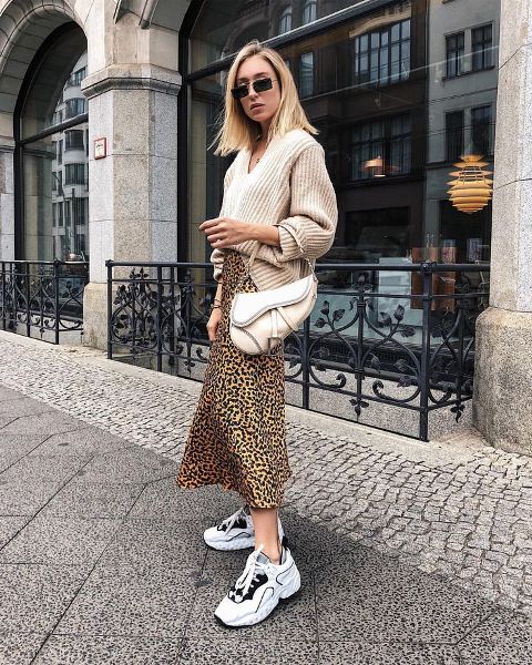With beige loose sweater, white bag and sneakers