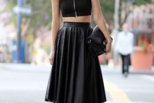 With black zipper top, leather clutch and lace up high heels