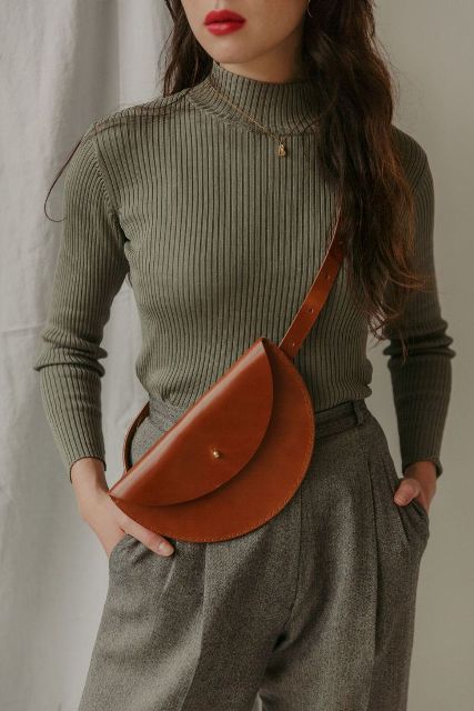 With olive green turtleneck and gray tweed trousers