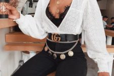 a black lace bra, a white perforated shirt, black skinnies, a gold chain belt with pendants